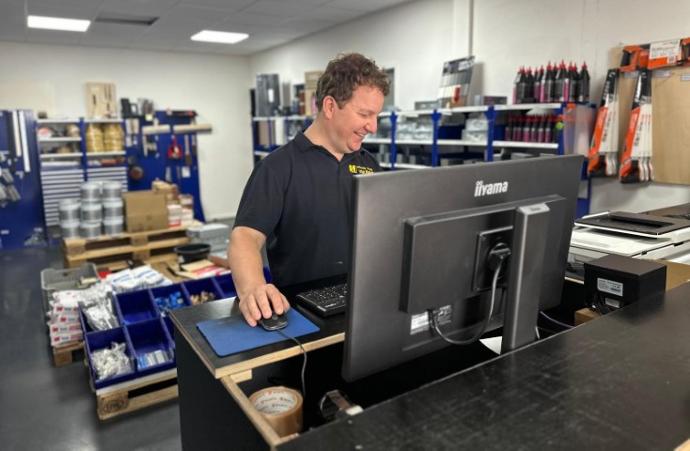 Verkoper achter de kassa, die een klant bedient