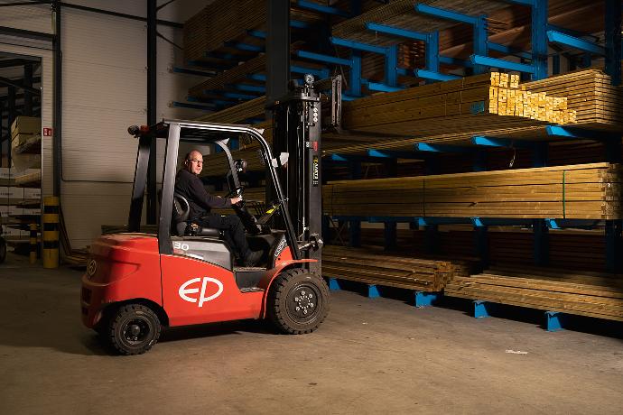 Heftruckchauffeur pakt houten balken uit de stelling.